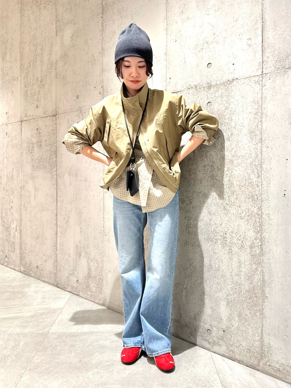 ベージュ系のナイロンジャケット、ブラウン系のスニーカー、ブラック系のショルダーバッグを着用したレディースの春コーディネートの3枚目の写真