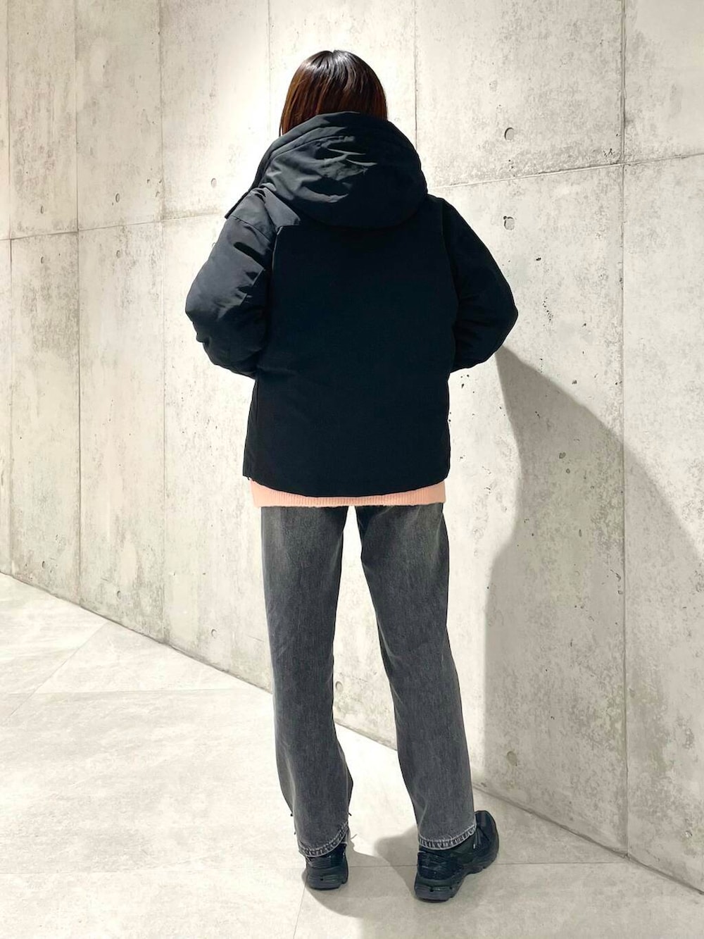 ブラック系のデニムパンツ、ブラック系のダウンジャケット/コート、ピンク系のニット/セーターを着用したレディースの秋コーディネートの3枚目の写真