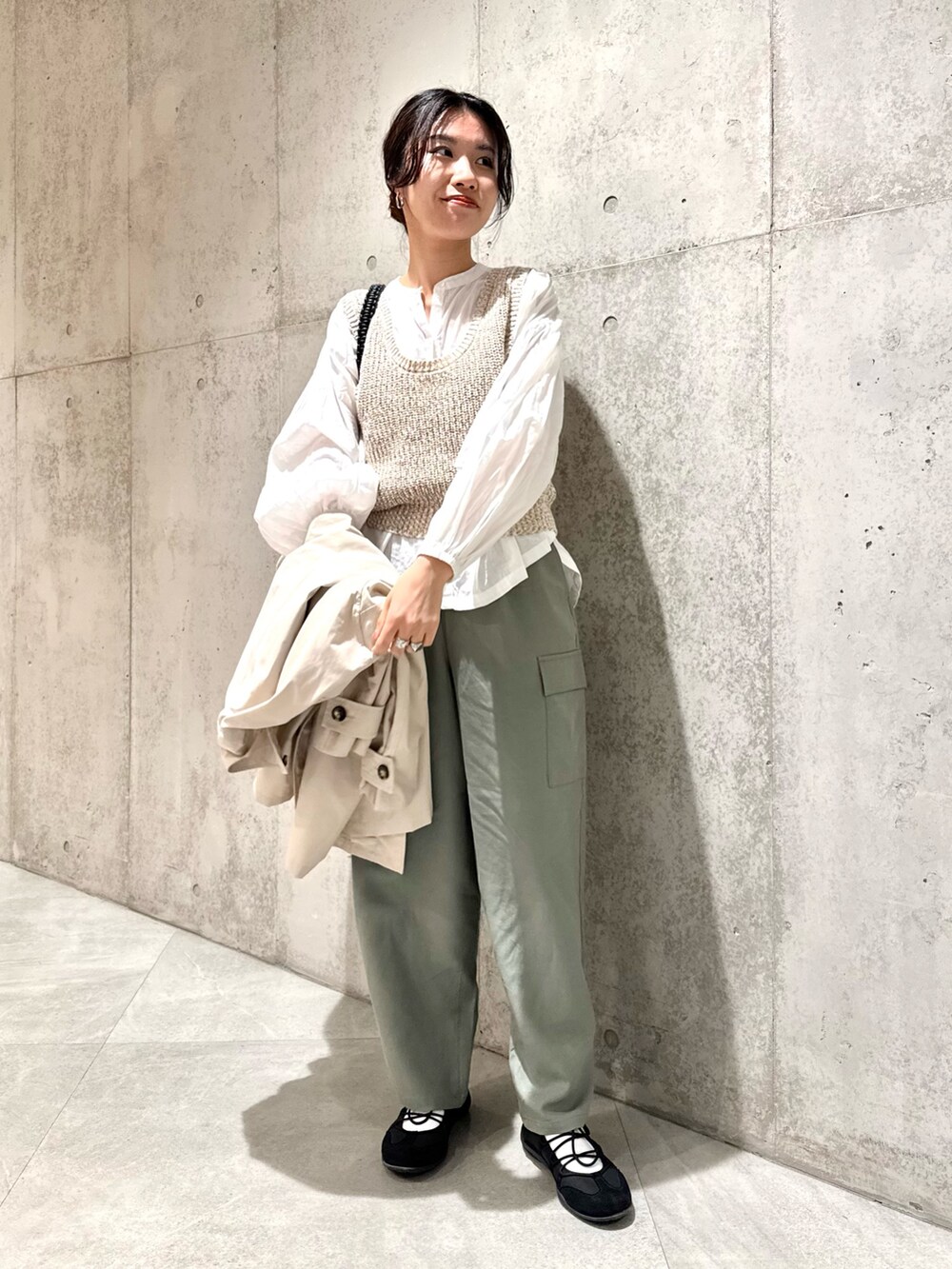 ホワイト系のシャツ/ブラウス、ベージュ系のベスト、ブラック系のスニーカーを着用したレディースの春コーディネートの5枚目の写真