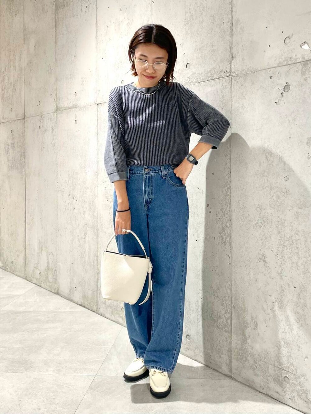 ベージュ系のショルダーバッグ、ホワイト系のローファー、ブラック系のニット/セーターを着用したレディースの夏コーディネートの3枚目の写真