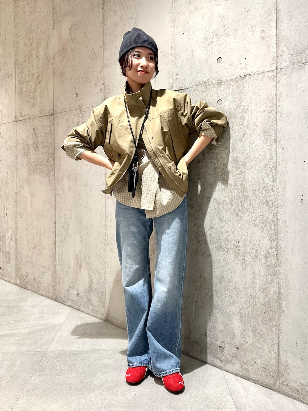 ベージュ系のナイロンジャケット、ブラウン系のスニーカー、ブラック系のショルダーバッグを着用したレディースの春コーディネートの4枚目の写真