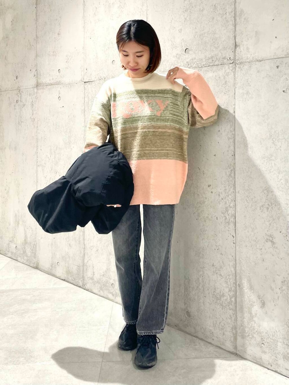 ブラック系のデニムパンツ、ブラック系のダウンジャケット/コート、ピンク系のニット/セーターを着用したレディースの秋コーディネートの5枚目の写真