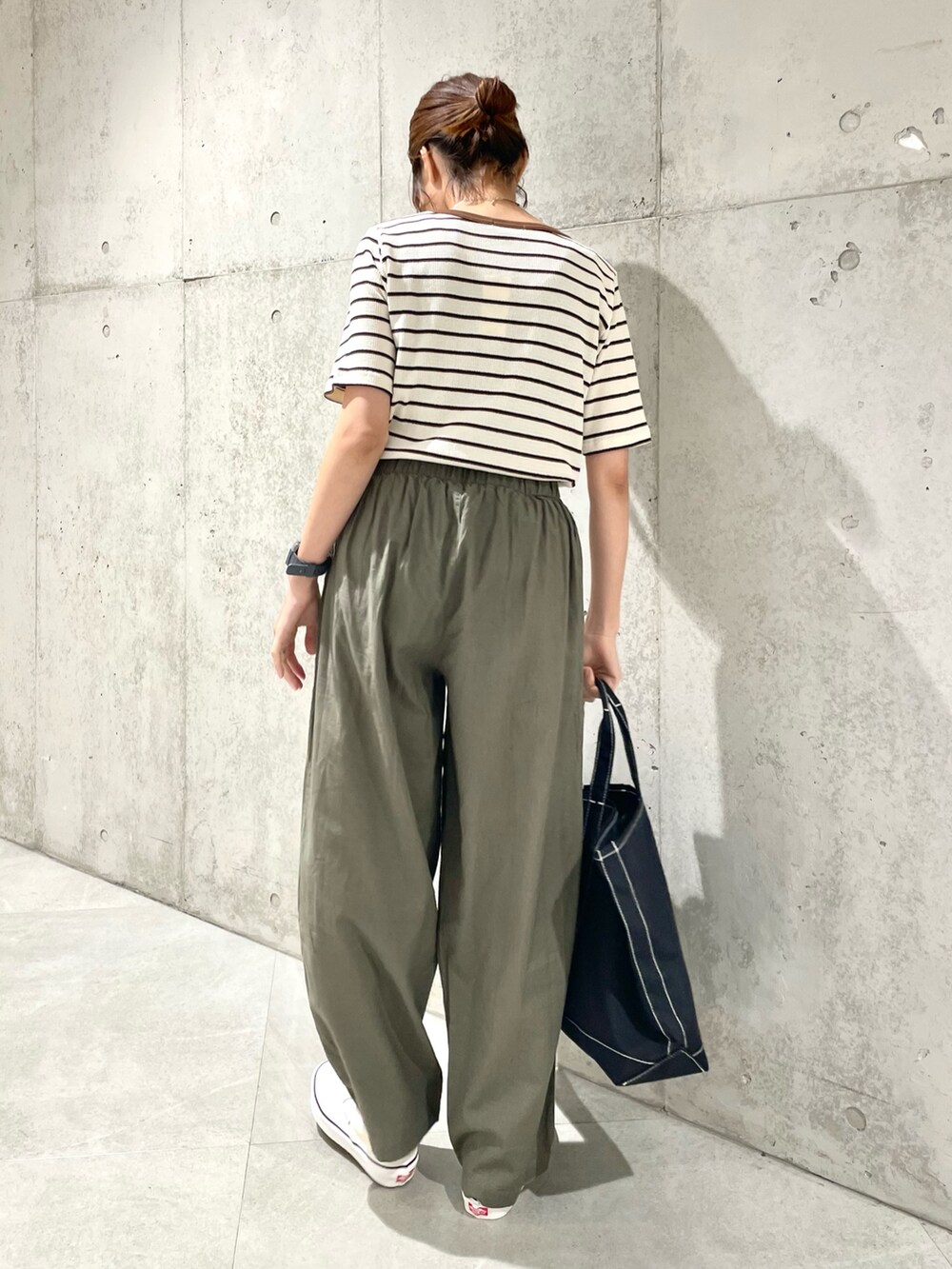 ホワイト系のスリッポン、ブラック系のトートバッグ、グリーン系のその他パンツを着用したレディースの夏コーディネートの4枚目の写真