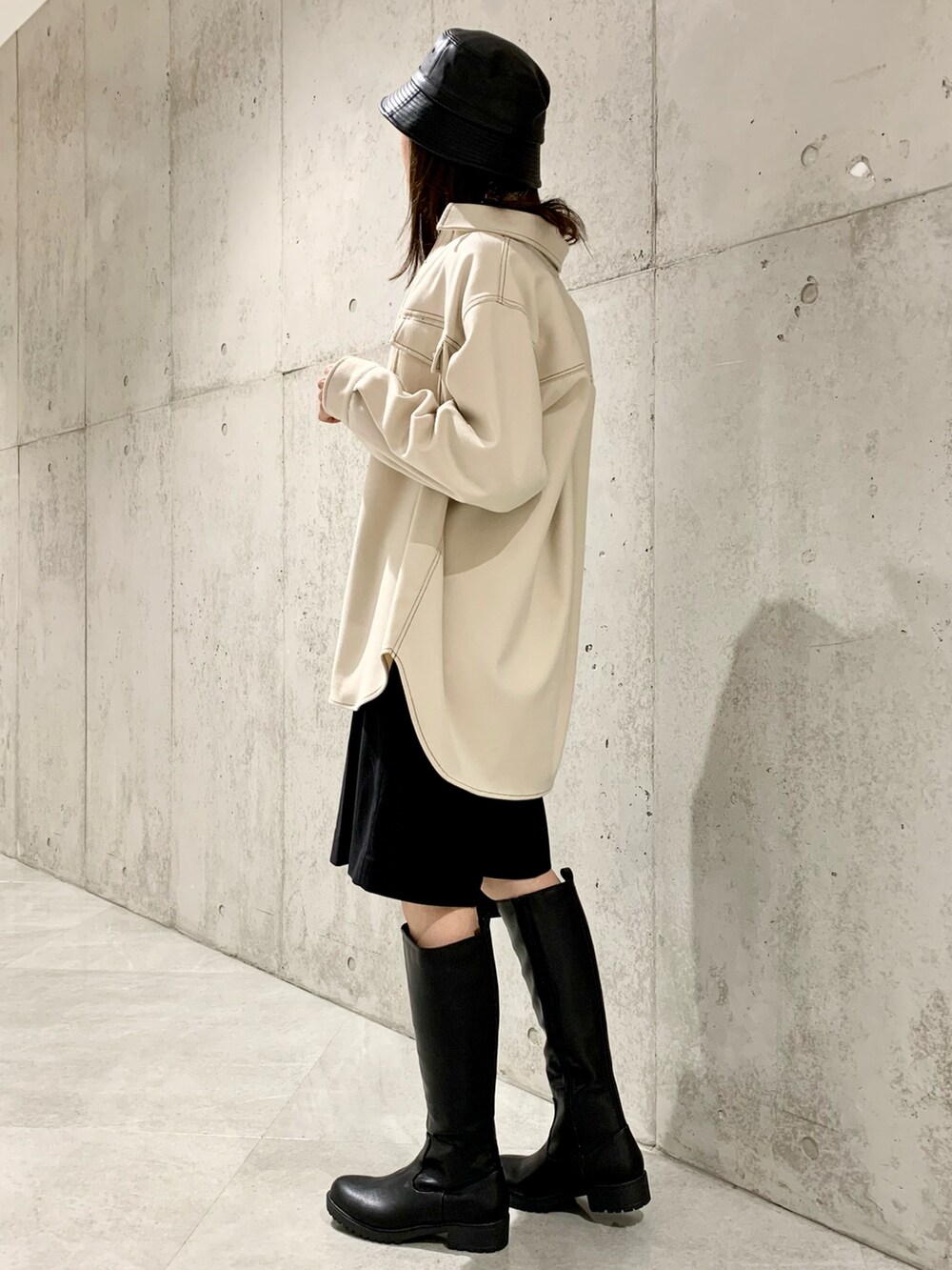 イエロー系のニット/セーター、ホワイト系のシャツ/ブラウス、ブラック系のその他パンツを着用したレディースの冬コーディネートの3枚目の写真