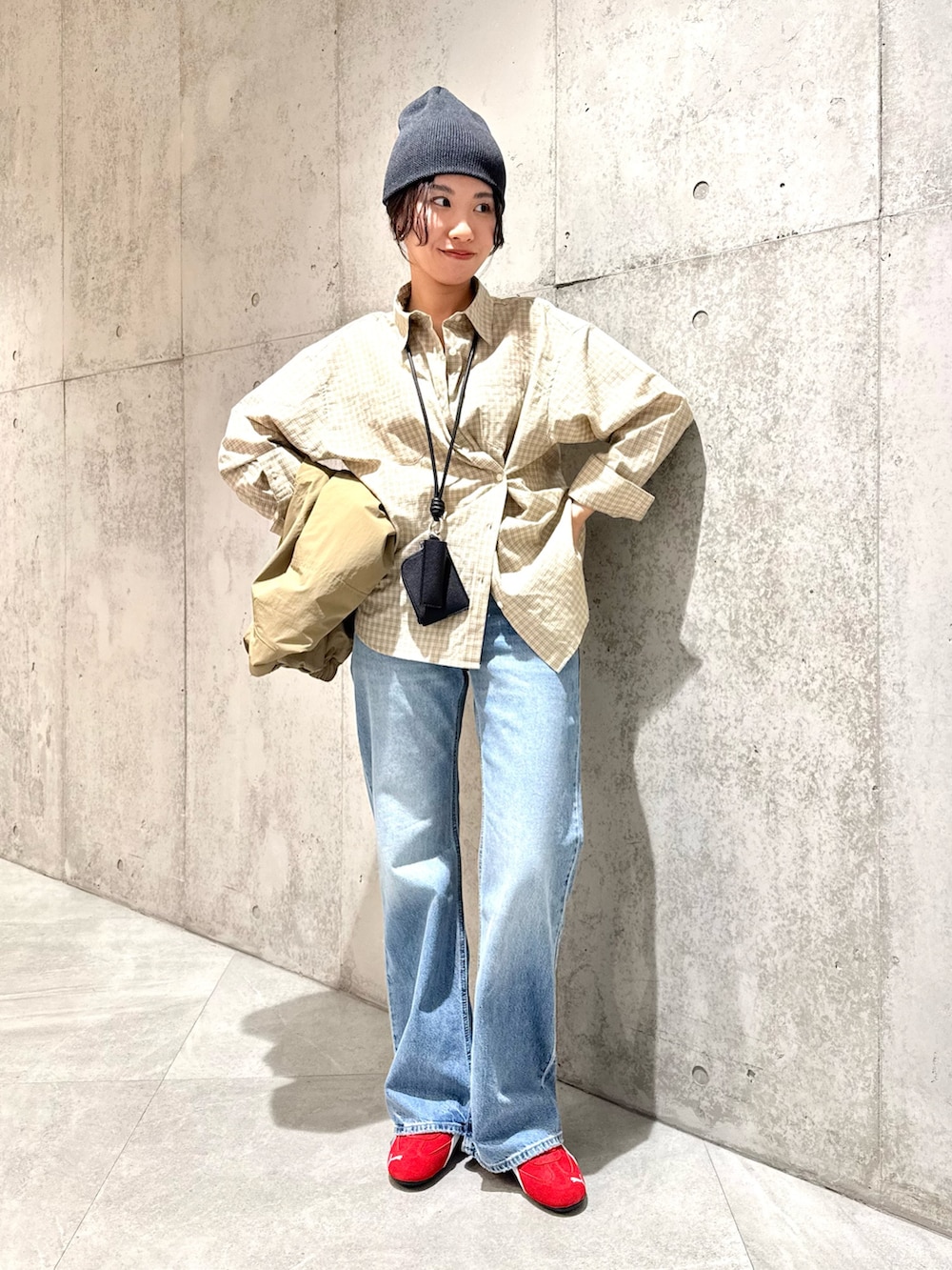 ベージュ系のナイロンジャケット、ブラウン系のスニーカー、ブラック系のショルダーバッグを着用したレディースの春コーディネートの2枚目の写真