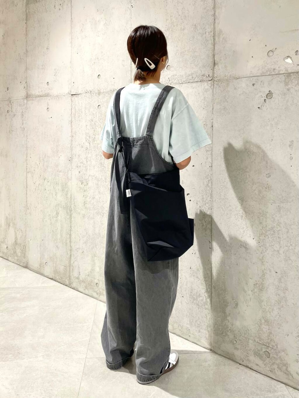 グレー系のサロペット/オーバーオール、グリーン系のTシャツ/カットソー、ホワイト系のスニーカーを着用したレディースの夏コーディネートの3枚目の写真