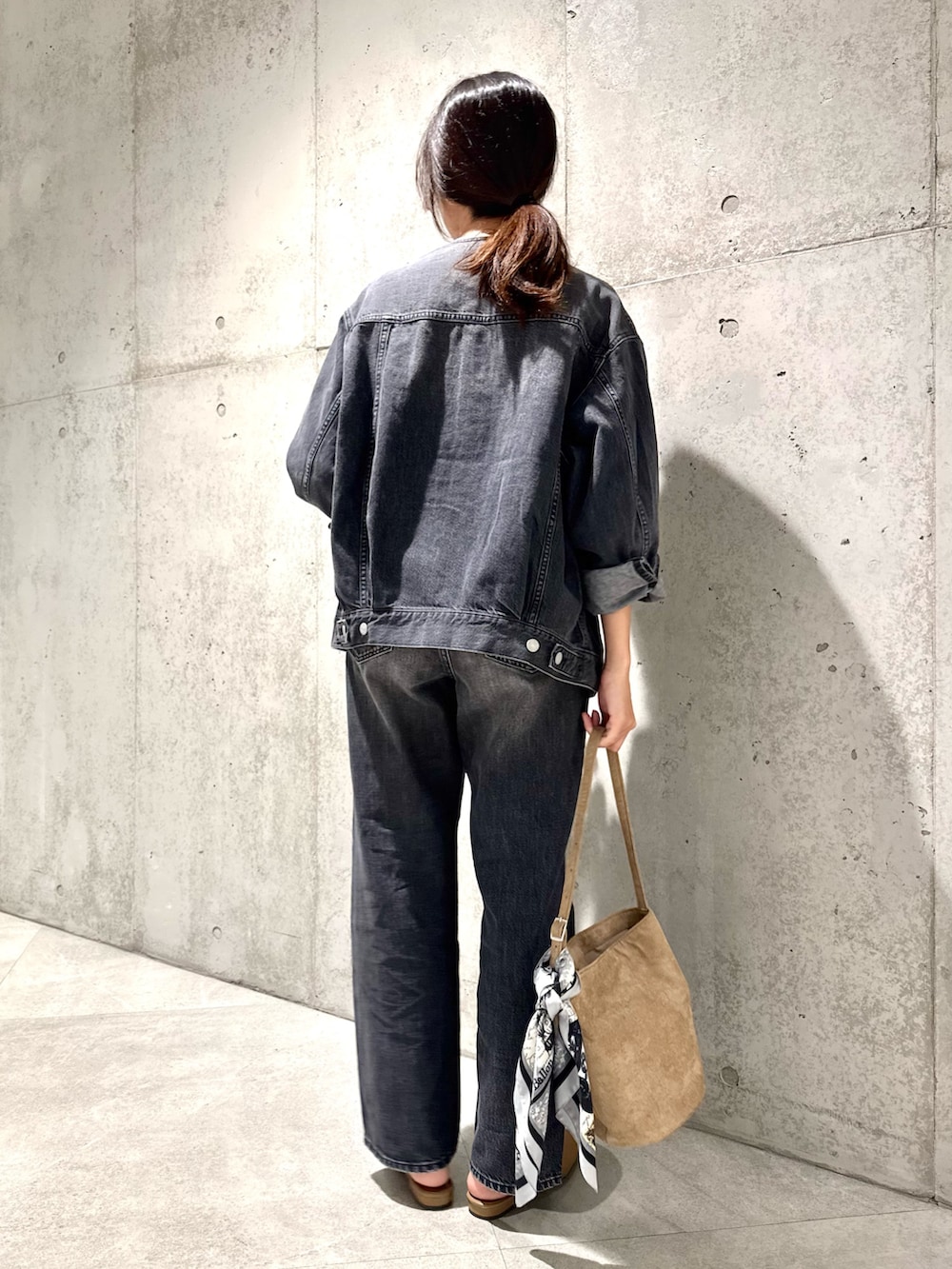 イエロー系のパンプス、グレー系のデニムジャケット、ベージュ系のショルダーバッグを着用したレディースの秋コーディネートの4枚目の写真