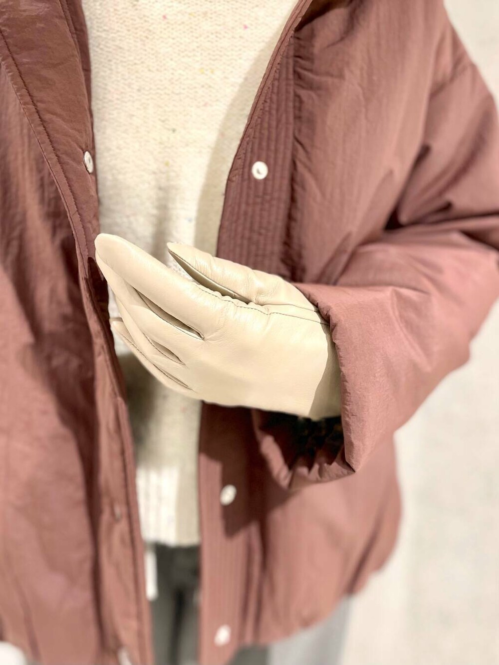 ブラウン系のブルゾン、ホワイト系のTシャツ/カットソー、ホワイト系のニット/セーターを着用したレディースの冬コーディネートの8枚目の写真