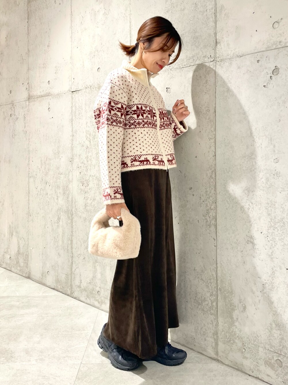 ベージュ系のハンドバッグ、ブラウン系のスカート、レッド系のニット/セーターを着用したレディースの秋コーディネートの2枚目の写真