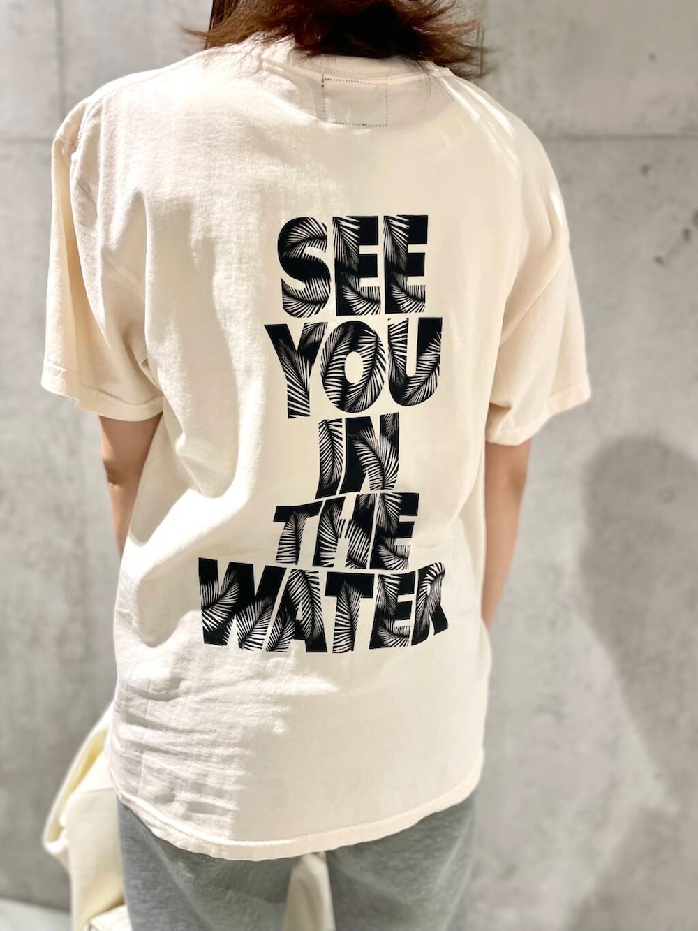 ブラック系のスニーカー、ホワイト系のTシャツ/カットソー、グレー系のその他パンツを着用したレディースの春コーディネートの5枚目の写真