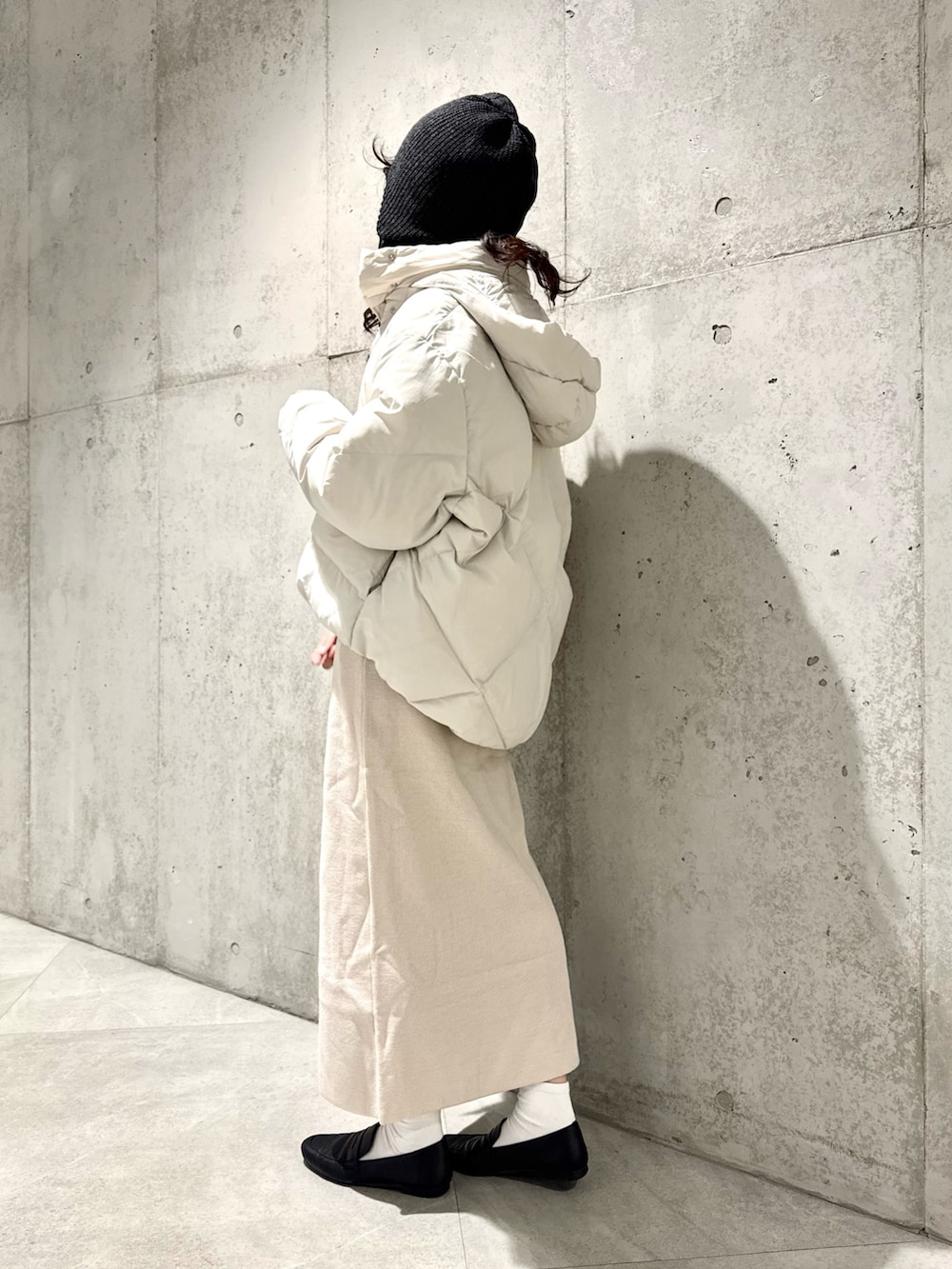 ホワイト系のスカート、グリーン系のニット/セーター、ホワイト系のダウンジャケット/コートを着用したレディースの秋コーディネートの3枚目の写真