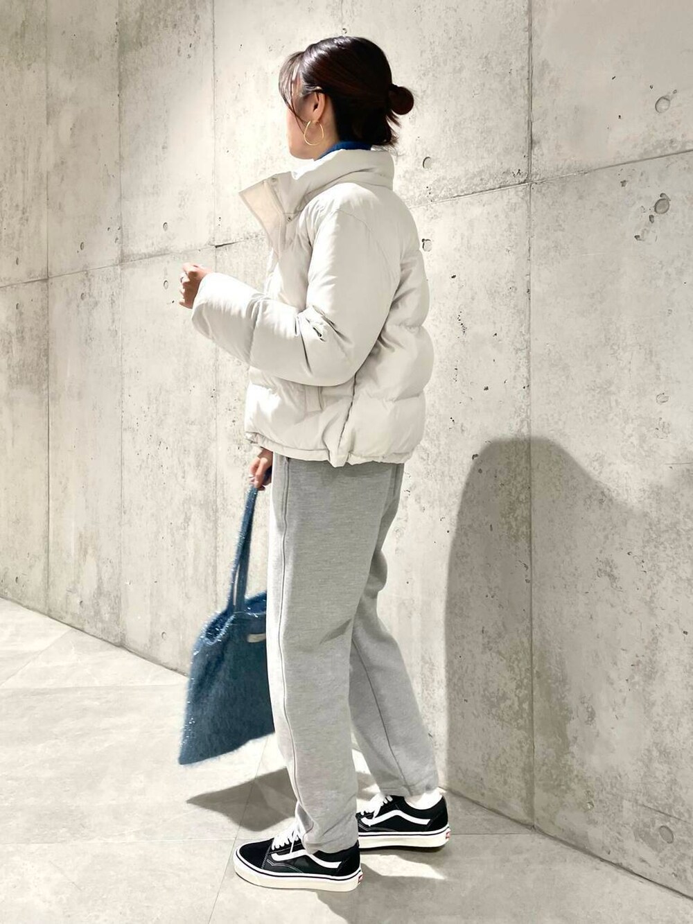 ブラック系のスニーカー、ブルー系のニット/セーター、ブルー系のトートバッグを着用したレディースの冬コーディネートの4枚目の写真