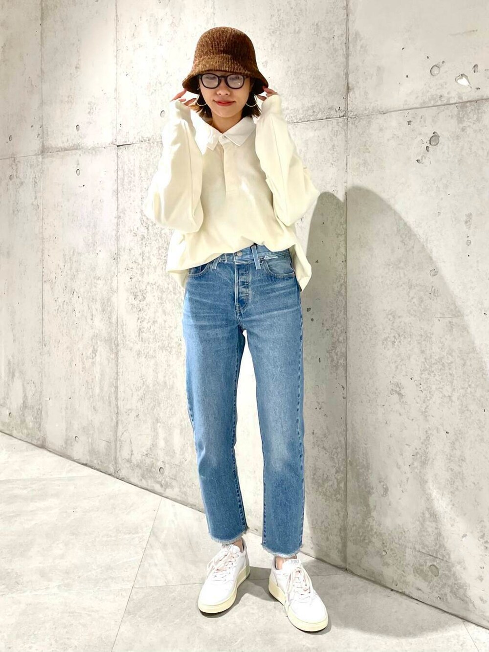 ベージュ系のポロシャツ、ブルー系のデニムパンツ、ホワイト系のスニーカーを着用したレディースの夏コーディネートの4枚目の写真