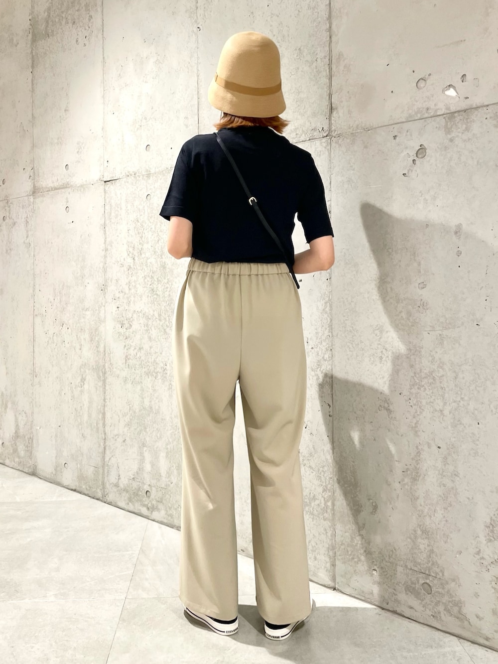 ブラック系のニット/セーター、ベージュ系のハットを着用したレディースの夏コーディネートの3枚目の写真