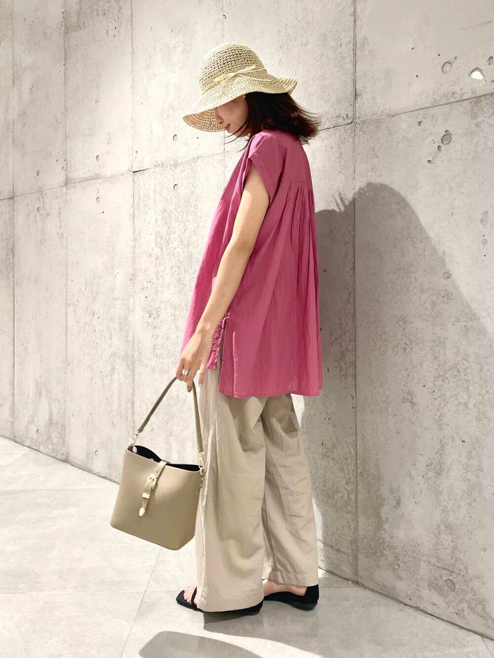 ベージュ系のショルダーバッグ、ピンク系のTシャツ/カットソー、ベージュ系のその他パンツを着用したレディースの夏コーディネートの4枚目の写真