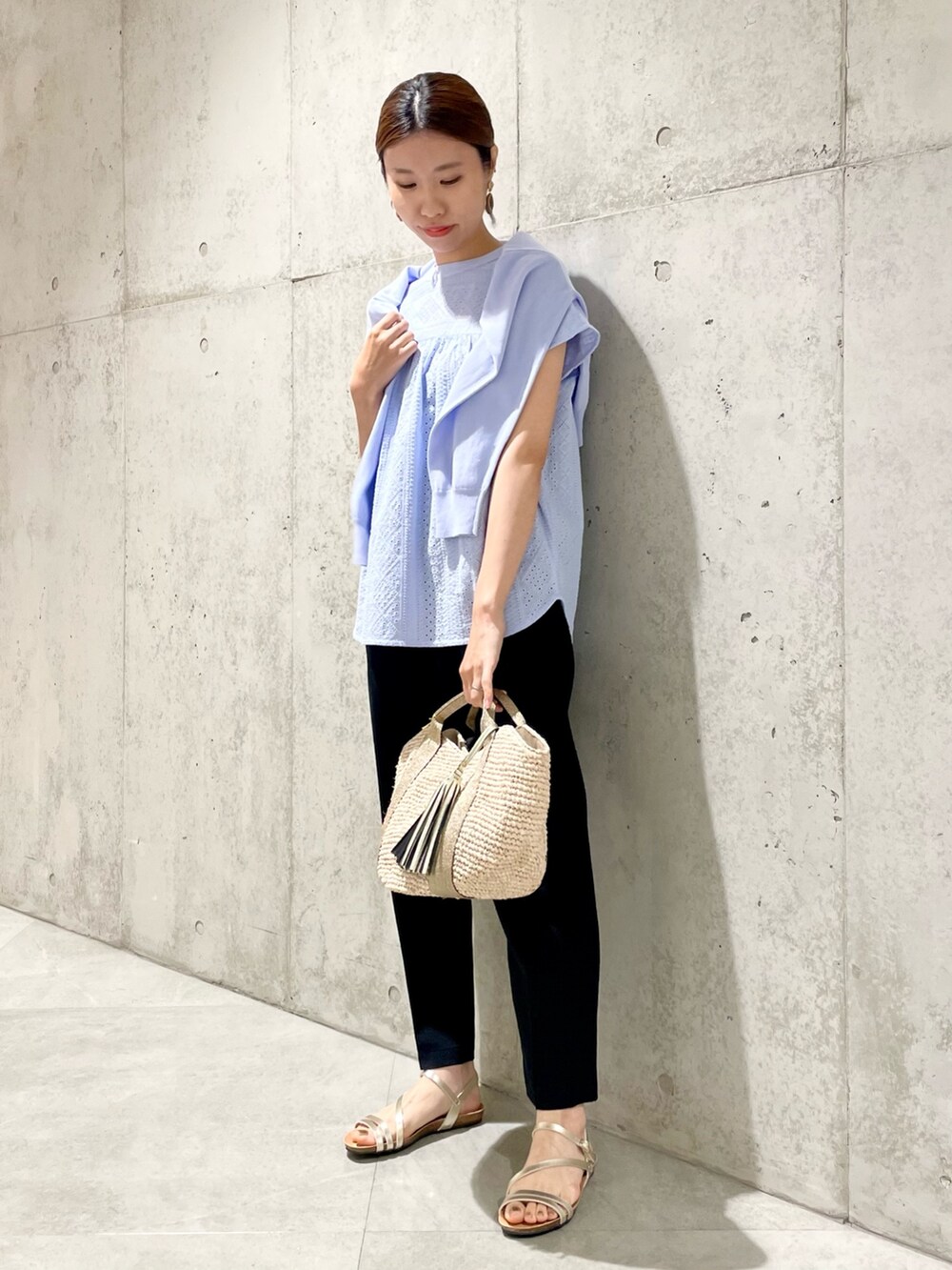 ゴールド系のかごバッグ、ゴールド系のサンダル、ブルー系のカーディガン/ボレロを着用したレディースの春コーディネートの2枚目の写真
