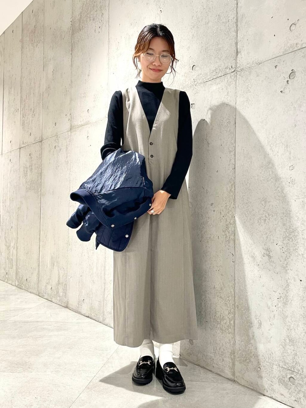 ブラック系のTシャツ/カットソー、ベージュ系のワンピース、ブラック系のローファーを着用したレディースの秋コーディネートの4枚目の写真