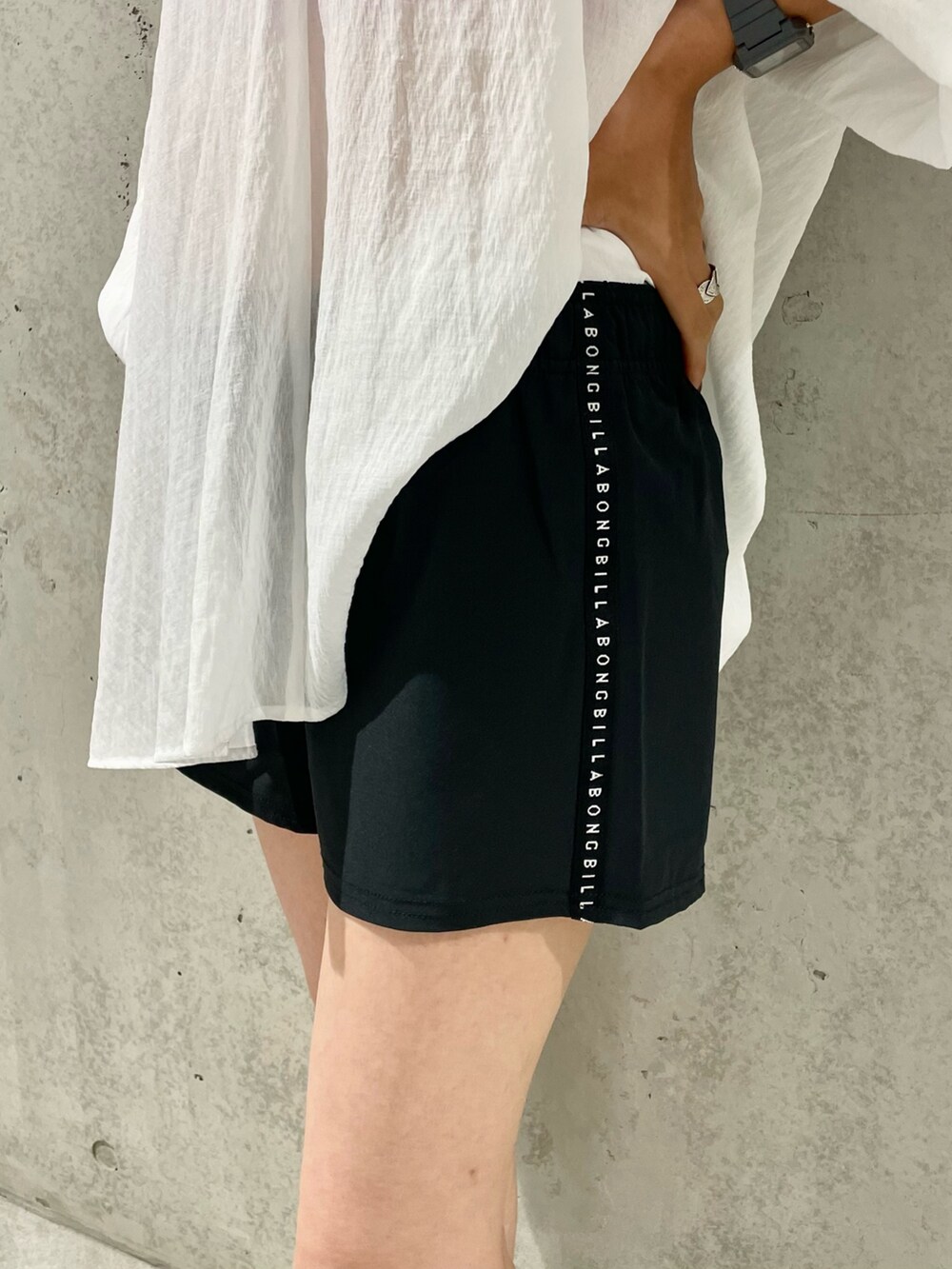 ブルー系のスニーカー、ブラック系のキャップ、シルバー系のネックレスを着用したレディースの夏コーディネートの5枚目の写真