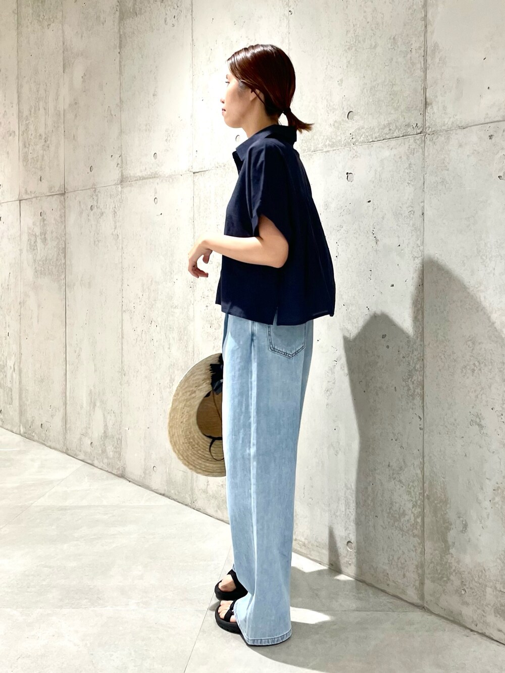 ブルー系のデニムパンツ、ブラック系のサンダル、ブルー系のシャツ/ブラウスを着用したレディースの夏コーディネートの2枚目の写真