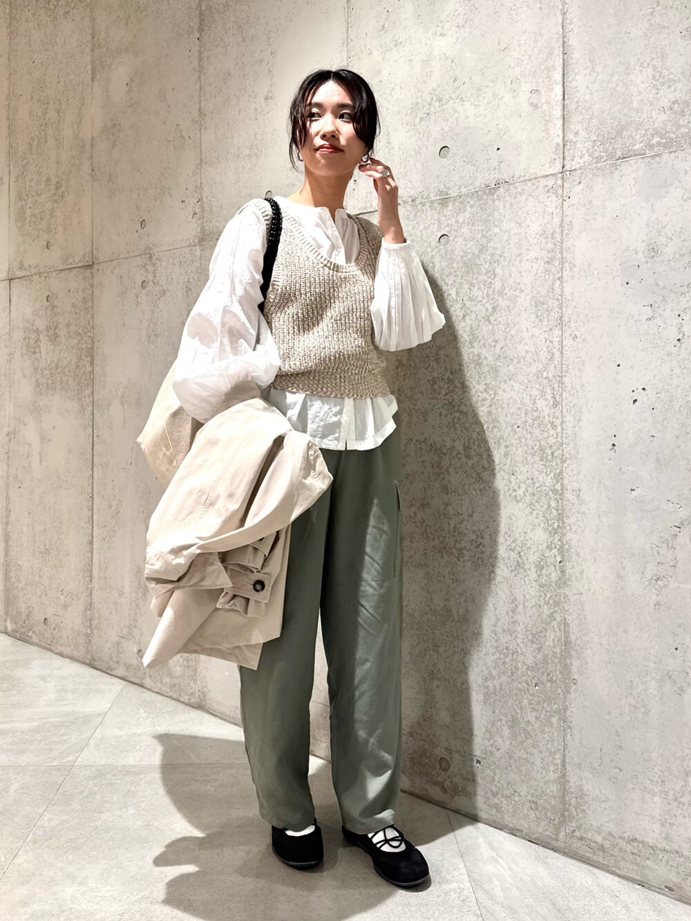 ホワイト系のシャツ/ブラウス、ベージュ系のベスト、ブラック系のスニーカーを着用したレディースの春コーディネートの6枚目の写真