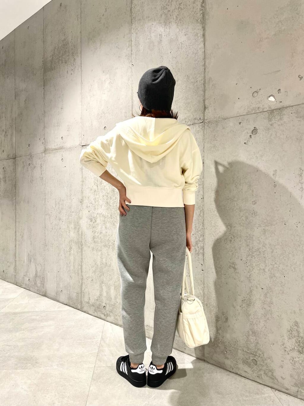 ブラック系のスニーカー、ホワイト系のTシャツ/カットソー、グレー系のその他パンツを着用したレディースの春コーディネートの4枚目の写真