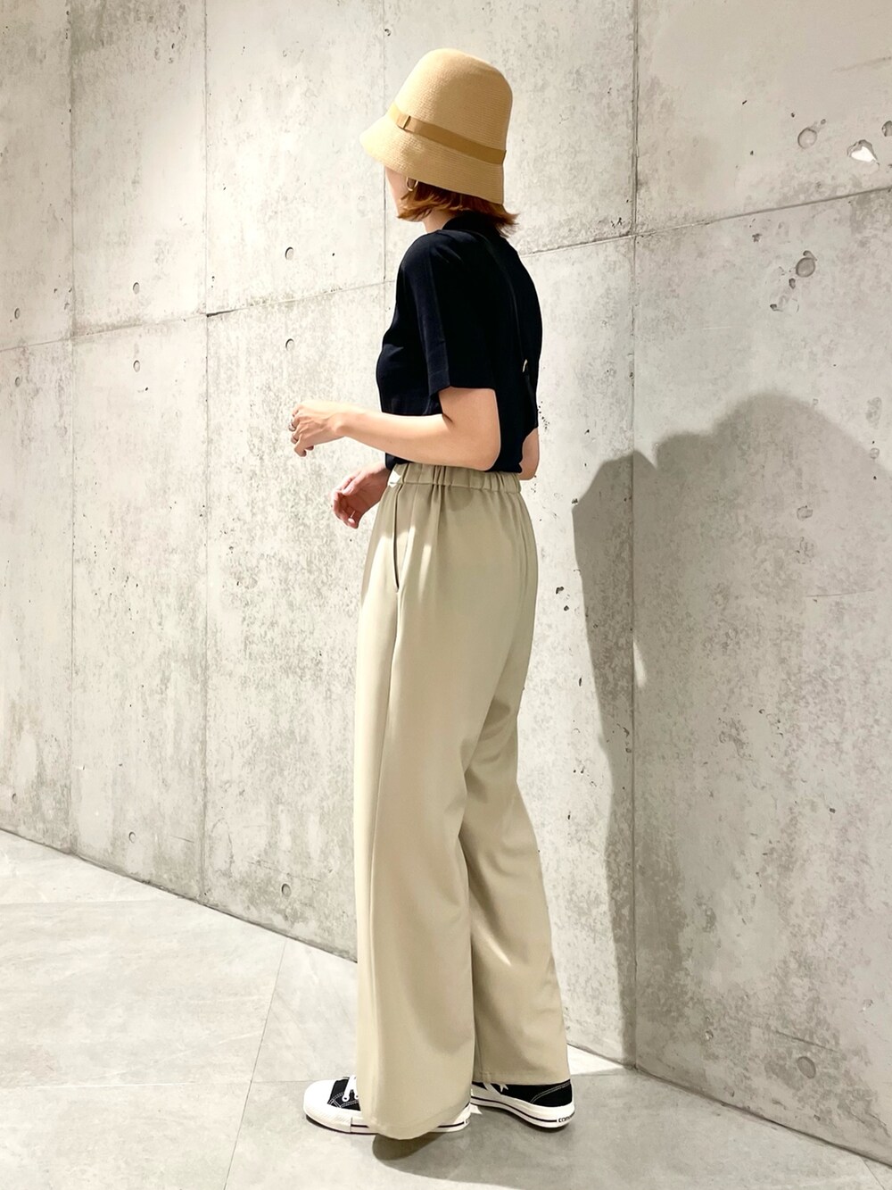 ブラック系のニット/セーター、ベージュ系のハットを着用したレディースの夏コーディネートの2枚目の写真