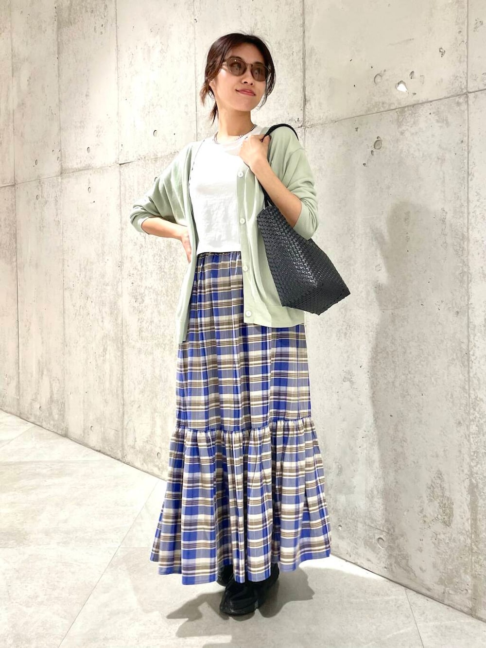 グリーン系のカーディガン/ボレロ、ホワイト系のTシャツ/カットソー、ブラック系のトートバッグを着用したレディースの春コーディネートの2枚目の写真