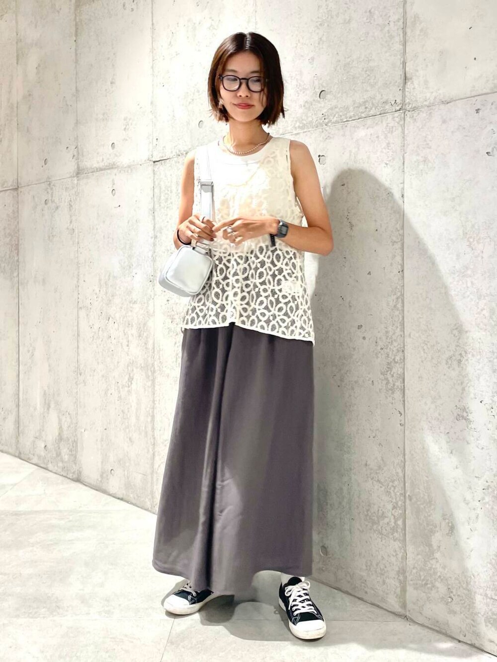 ホワイト系のタンクトップ、ホワイト系のベスト、シルバー系のショルダーバッグを着用したレディースの夏コーディネートの2枚目の写真