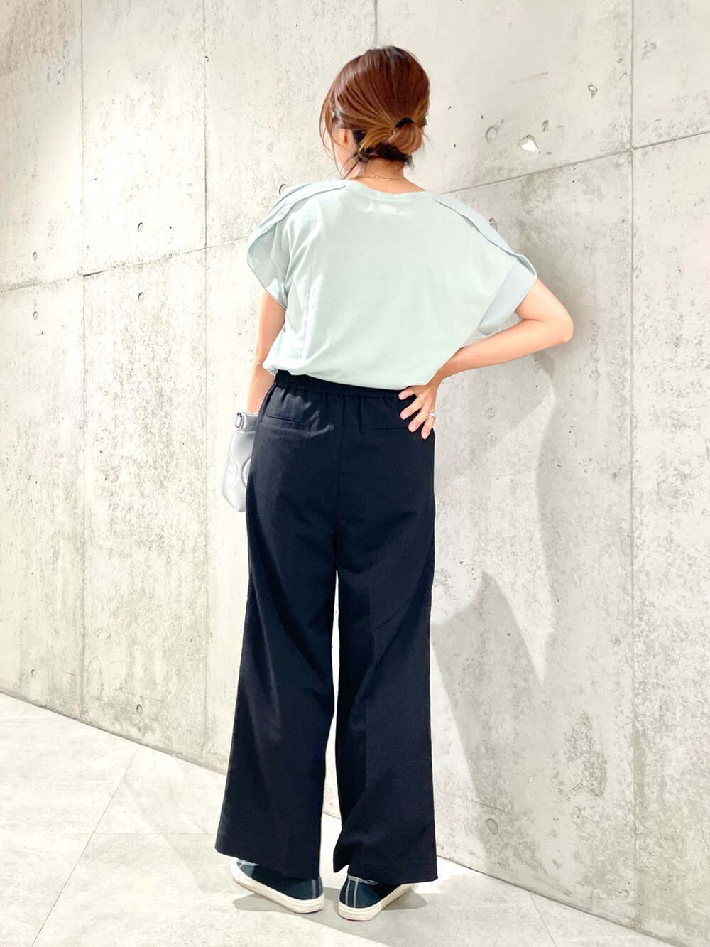 シルバー系のクラッチバッグ、グリーン系のTシャツ/カットソー、ブラック系のその他パンツを着用したレディースの夏コーディネートの4枚目の写真