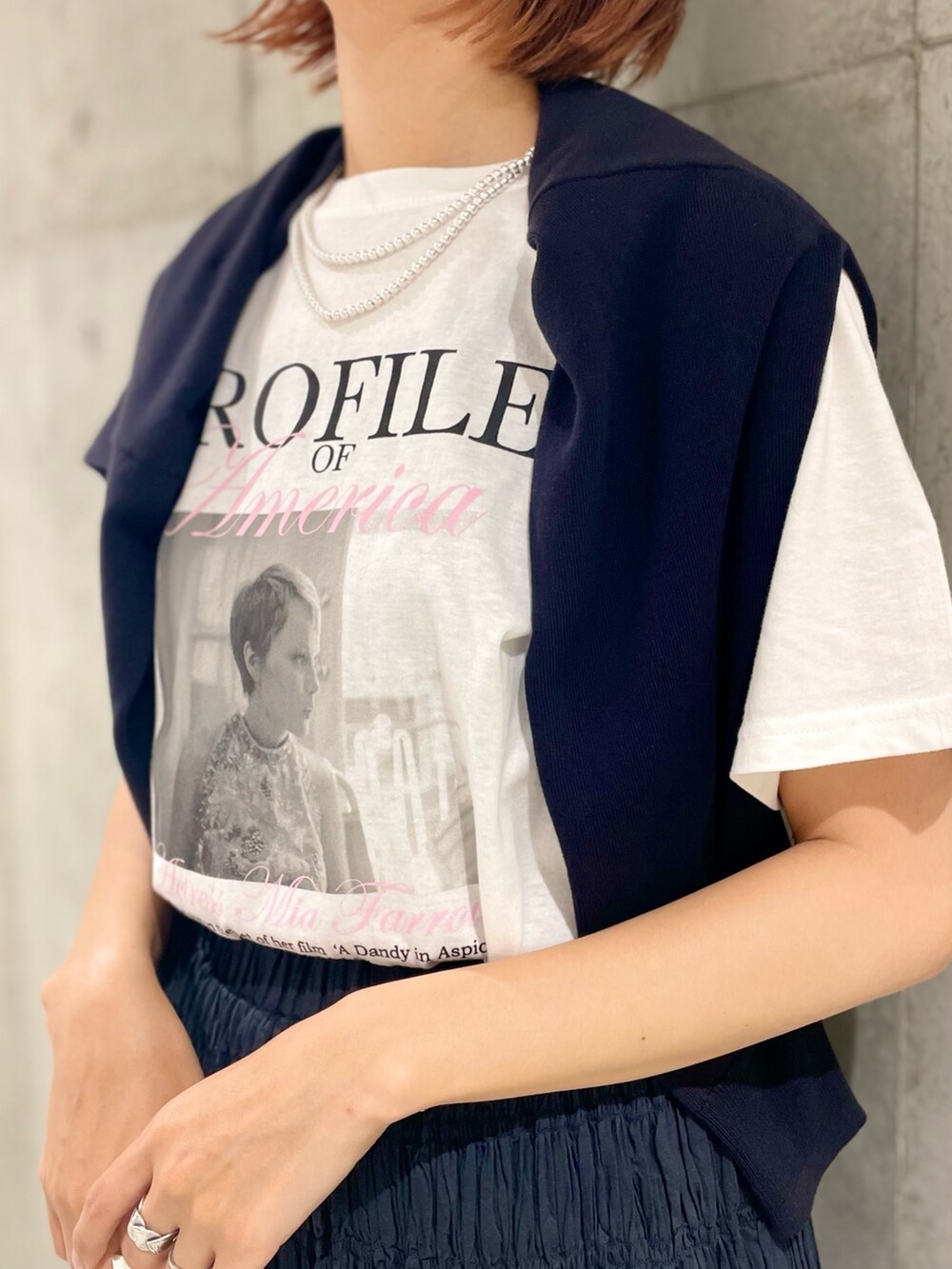 ホワイト系のショルダーバッグ、ブラック系のカーディガン/ボレロ、ブラック系のスカートを着用したレディースの夏コーディネートの3枚目の写真