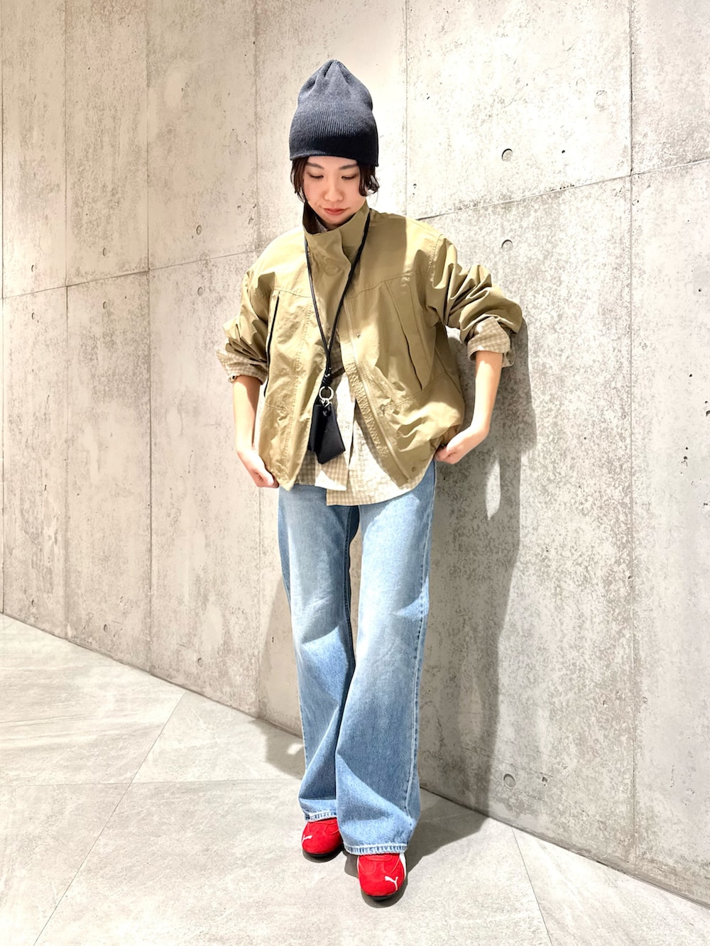 ベージュ系のナイロンジャケット、ブラウン系のスニーカー、ブラック系のショルダーバッグを着用したレディースの春コーディネートの5枚目の写真