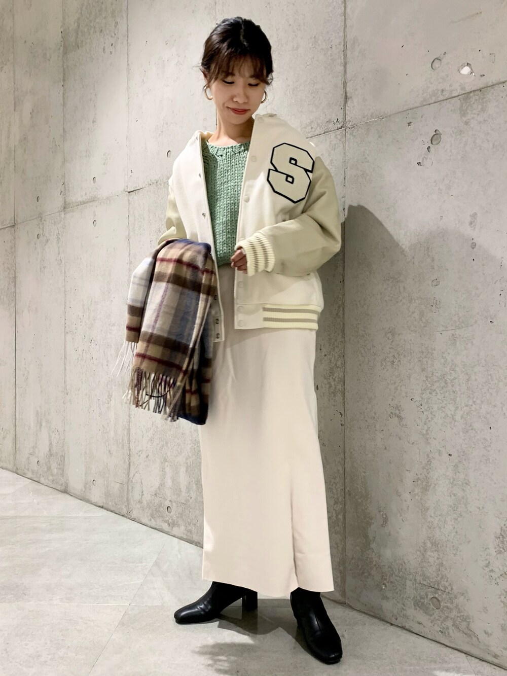 ホワイト系のスタジャン、ホワイト系のスカート、グリーン系のニット/セーターを着用したレディースの秋コーディネートの2枚目の写真