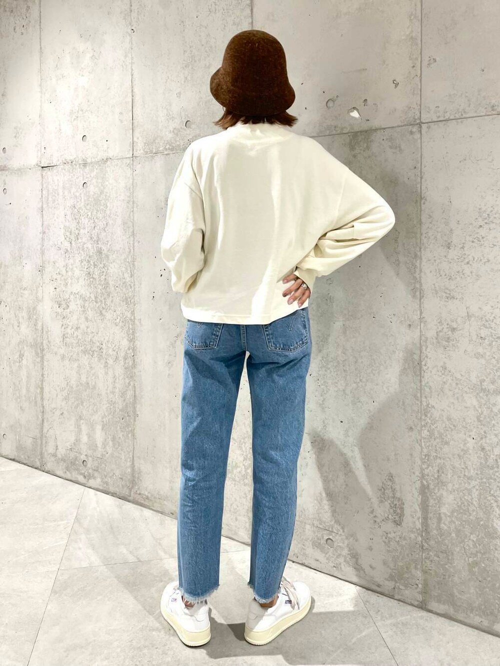 ベージュ系のポロシャツ、ブルー系のデニムパンツ、ホワイト系のスニーカーを着用したレディースの夏コーディネートの6枚目の写真