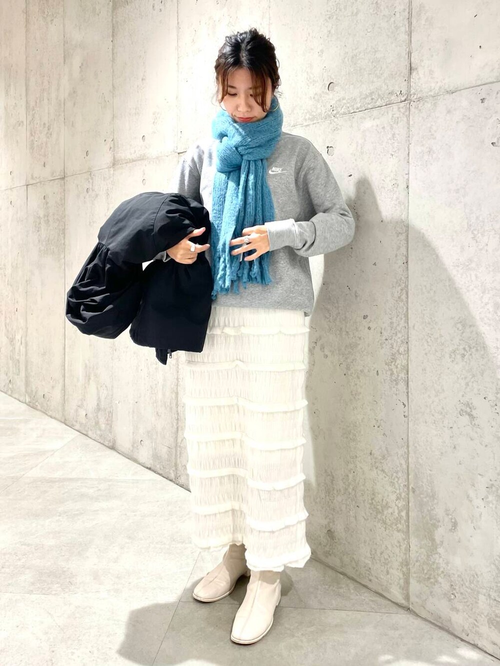 ブラック系のダウンジャケット/コート、グレー系のスウェット、ホワイト系のスカートを着用したレディースの秋コーディネートの4枚目の写真