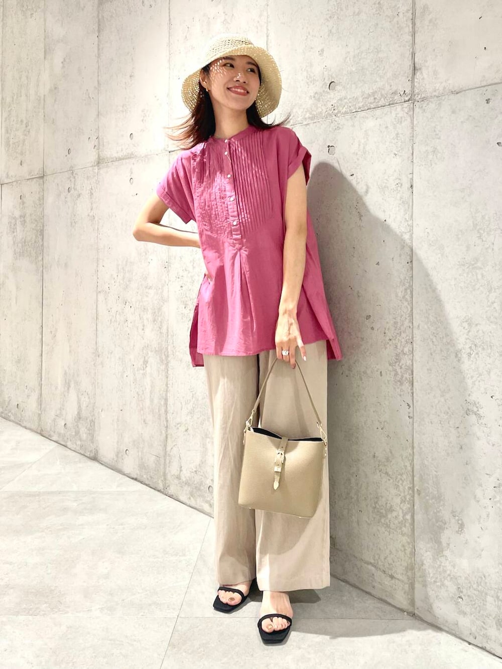 ベージュ系のショルダーバッグ、ピンク系のTシャツ/カットソー、ベージュ系のその他パンツを着用したレディースの夏コーディネートの2枚目の写真