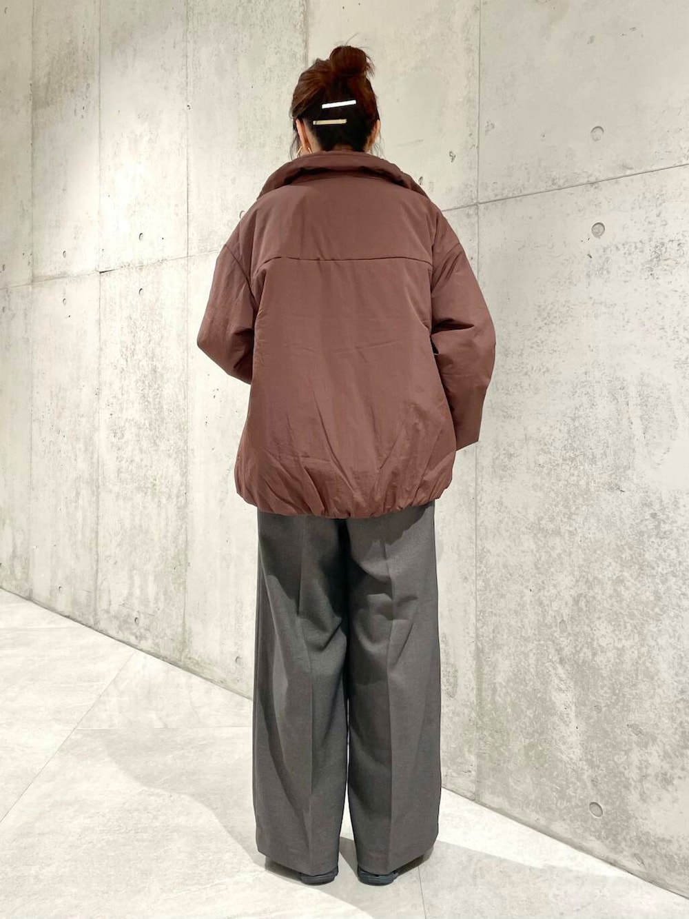 ブラウン系のブルゾン、ホワイト系のTシャツ/カットソー、ホワイト系のニット/セーターを着用したレディースの冬コーディネートの6枚目の写真