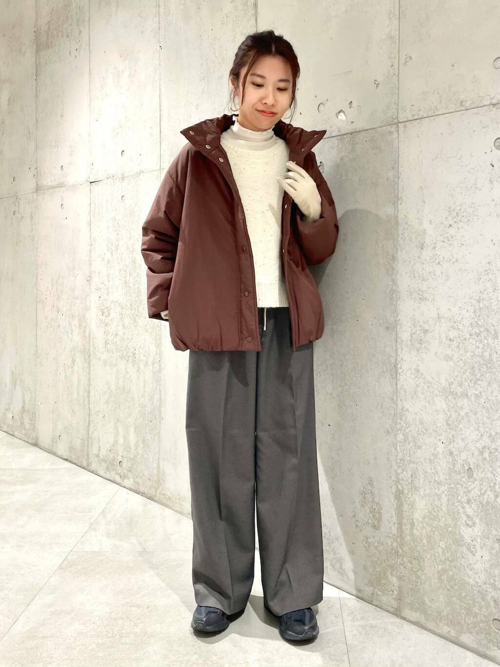 ブラウン系のブルゾン、ホワイト系のTシャツ/カットソー、ホワイト系のニット/セーターを着用したレディースの冬コーディネートの4枚目の写真