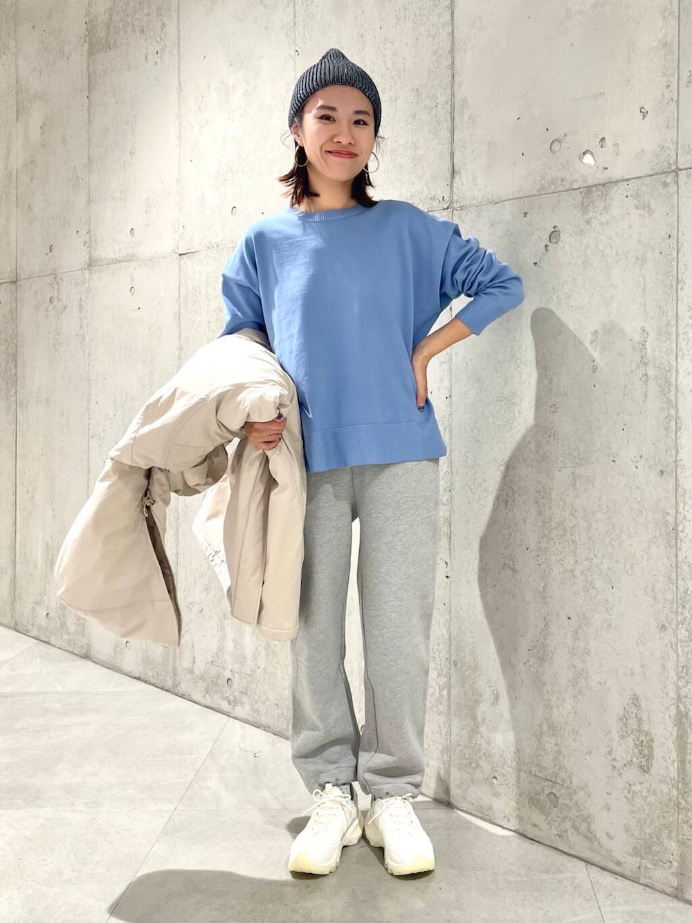 ホワイト系のスニーカー、ベージュ系のダウンジャケット/コート、ブルー系のニット/セーターを着用したレディースの冬コーディネートの5枚目の写真