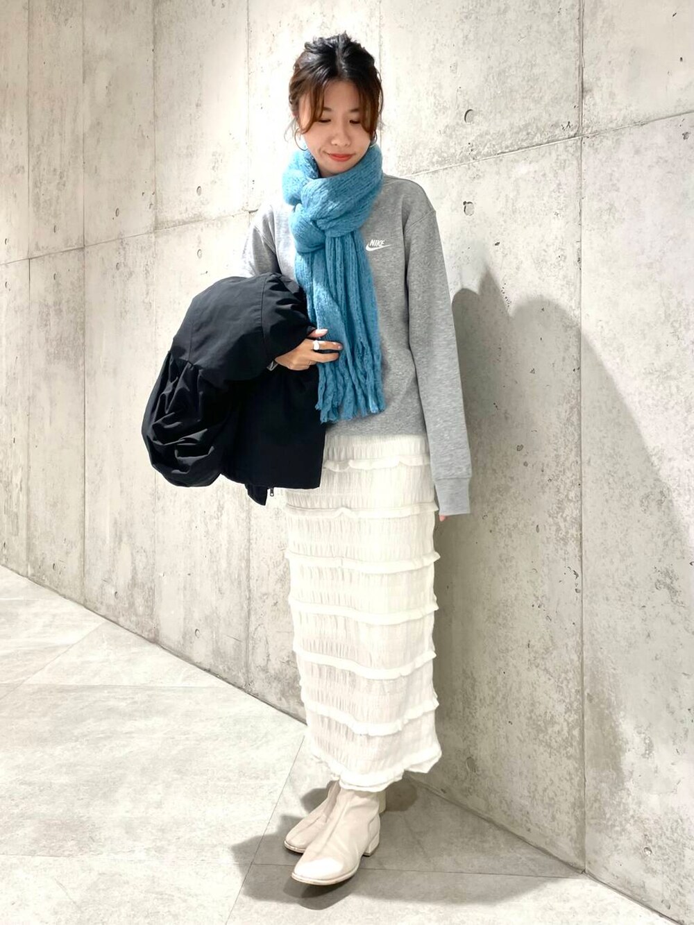 ブラック系のダウンジャケット/コート、グレー系のスウェット、ホワイト系のスカートを着用したレディースの秋コーディネートの5枚目の写真