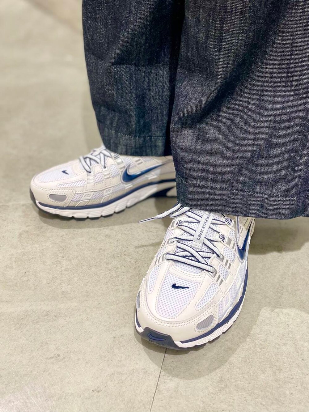 ブラック系のサロペット/オーバーオール、イエロー系のTシャツ/カットソー、ホワイト系のスニーカーを着用したレディースの秋コーディネートの4枚目の写真