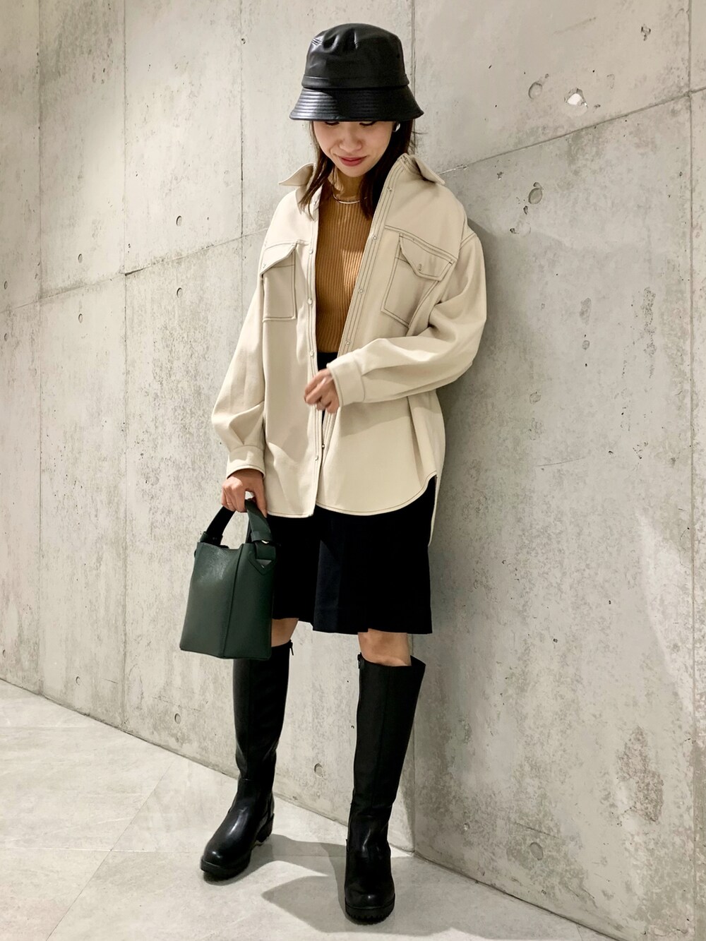 イエロー系のニット/セーター、ホワイト系のシャツ/ブラウス、ブラック系のその他パンツを着用したレディースの冬コーディネートの2枚目の写真