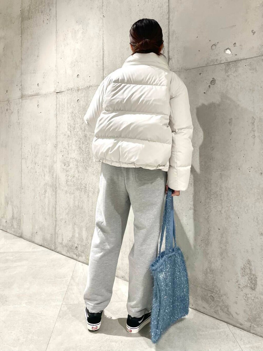 ブラック系のスニーカー、ブルー系のニット/セーター、ブルー系のトートバッグを着用したレディースの冬コーディネートの5枚目の写真