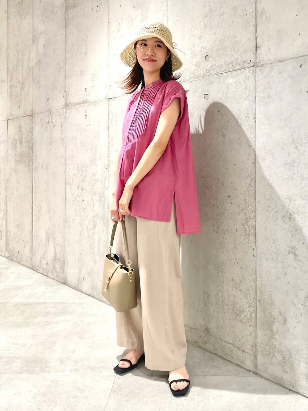 ベージュ系のショルダーバッグ、ピンク系のTシャツ/カットソー、ベージュ系のその他パンツを着用したレディースの夏コーディネートの3枚目の写真
