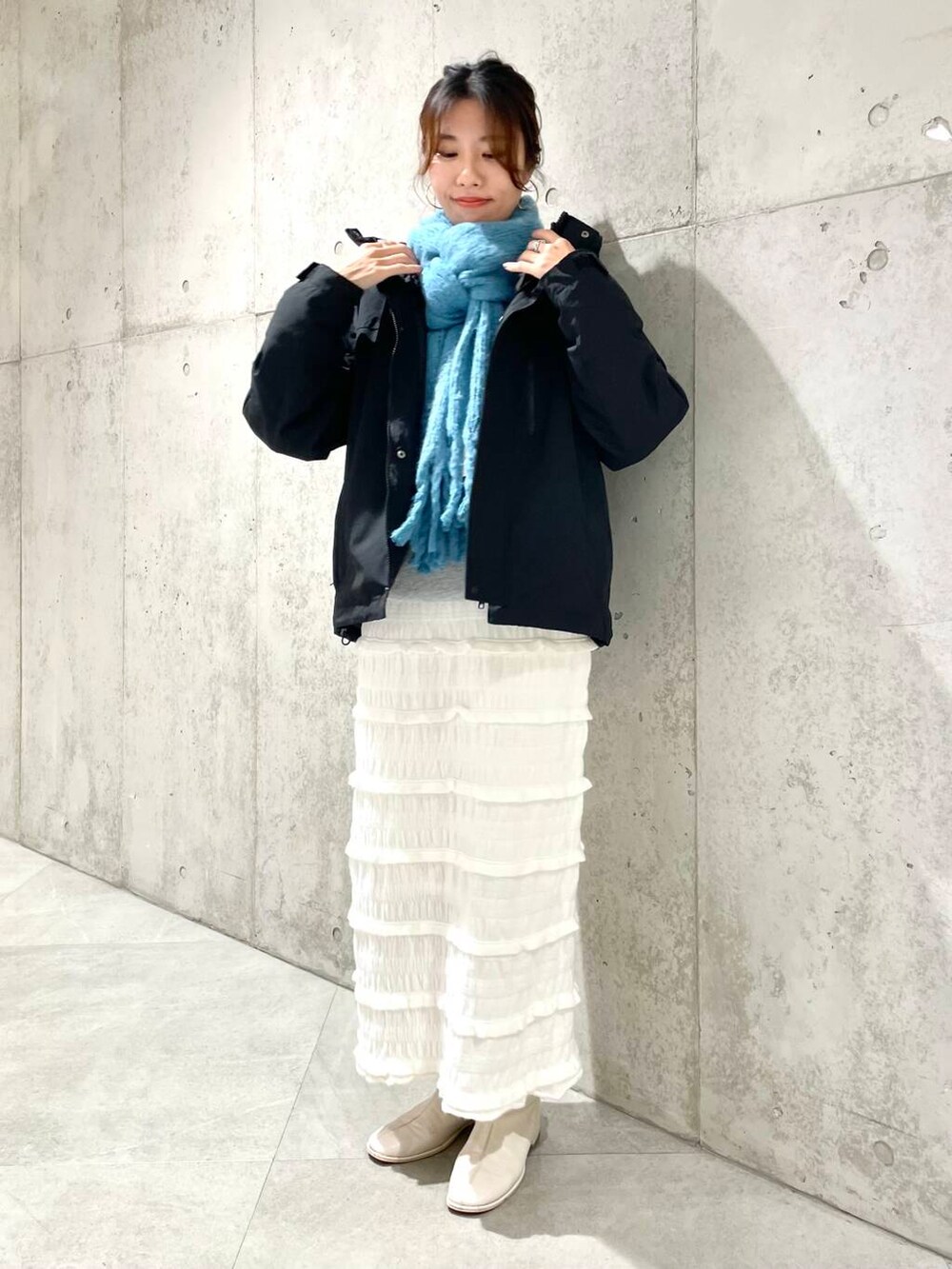 ブラック系のダウンジャケット/コート、グレー系のスウェット、ホワイト系のスカートを着用したレディースの秋コーディネートの2枚目の写真