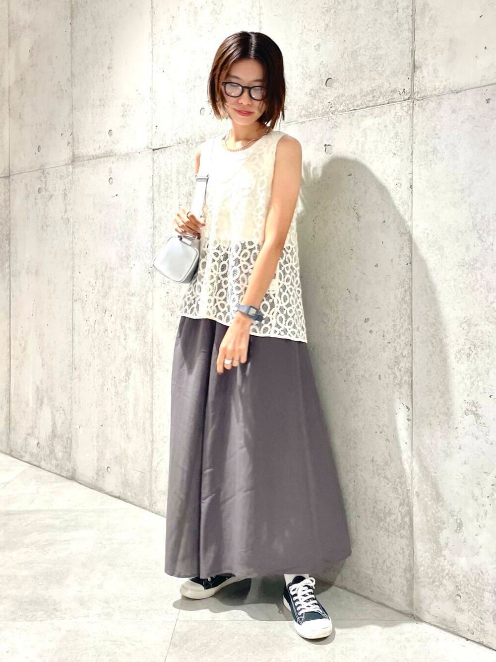 ホワイト系のタンクトップ、ホワイト系のベスト、シルバー系のショルダーバッグを着用したレディースの夏コーディネートの3枚目の写真