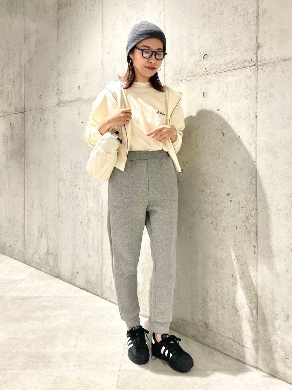 ブラック系のスニーカー、ホワイト系のTシャツ/カットソー、グレー系のその他パンツを着用したレディースの春コーディネートの3枚目の写真