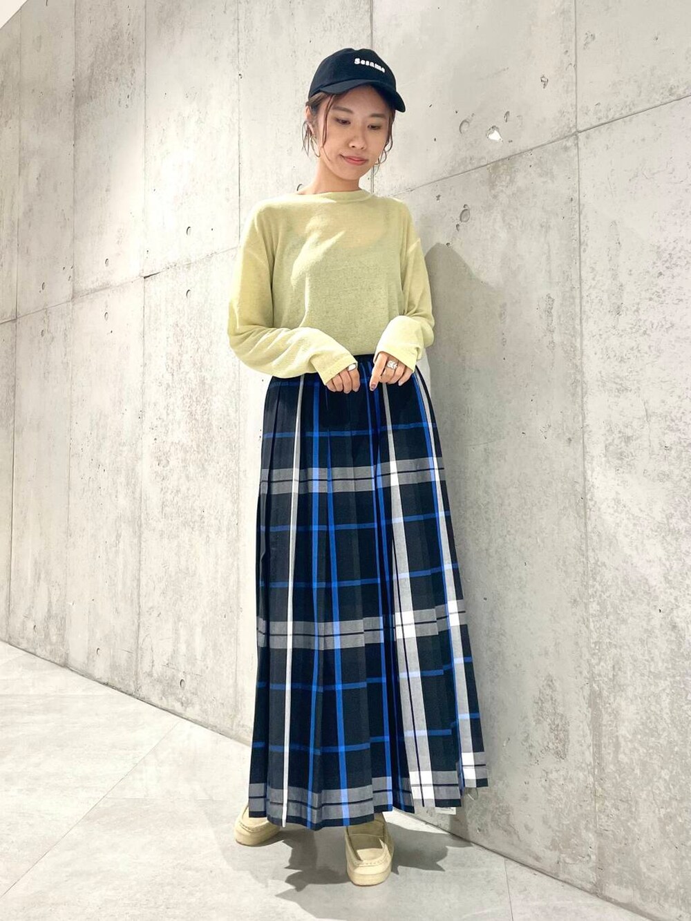 ベージュ系のローファー、イエロー系のTシャツ/カットソー、ブラック系のスカートを着用したレディースの夏コーディネートの3枚目の写真