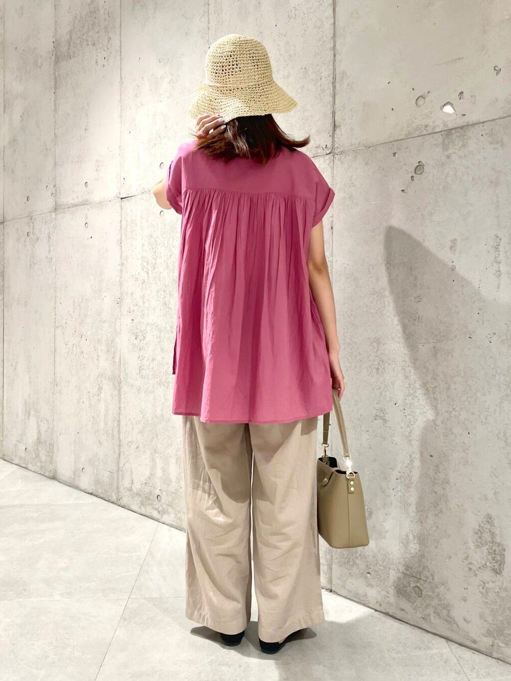 ベージュ系のショルダーバッグ、ピンク系のTシャツ/カットソー、ベージュ系のその他パンツを着用したレディースの夏コーディネートの5枚目の写真