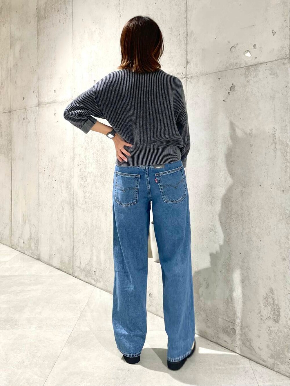 ベージュ系のショルダーバッグ、ホワイト系のローファー、ブラック系のニット/セーターを着用したレディースの夏コーディネートの4枚目の写真