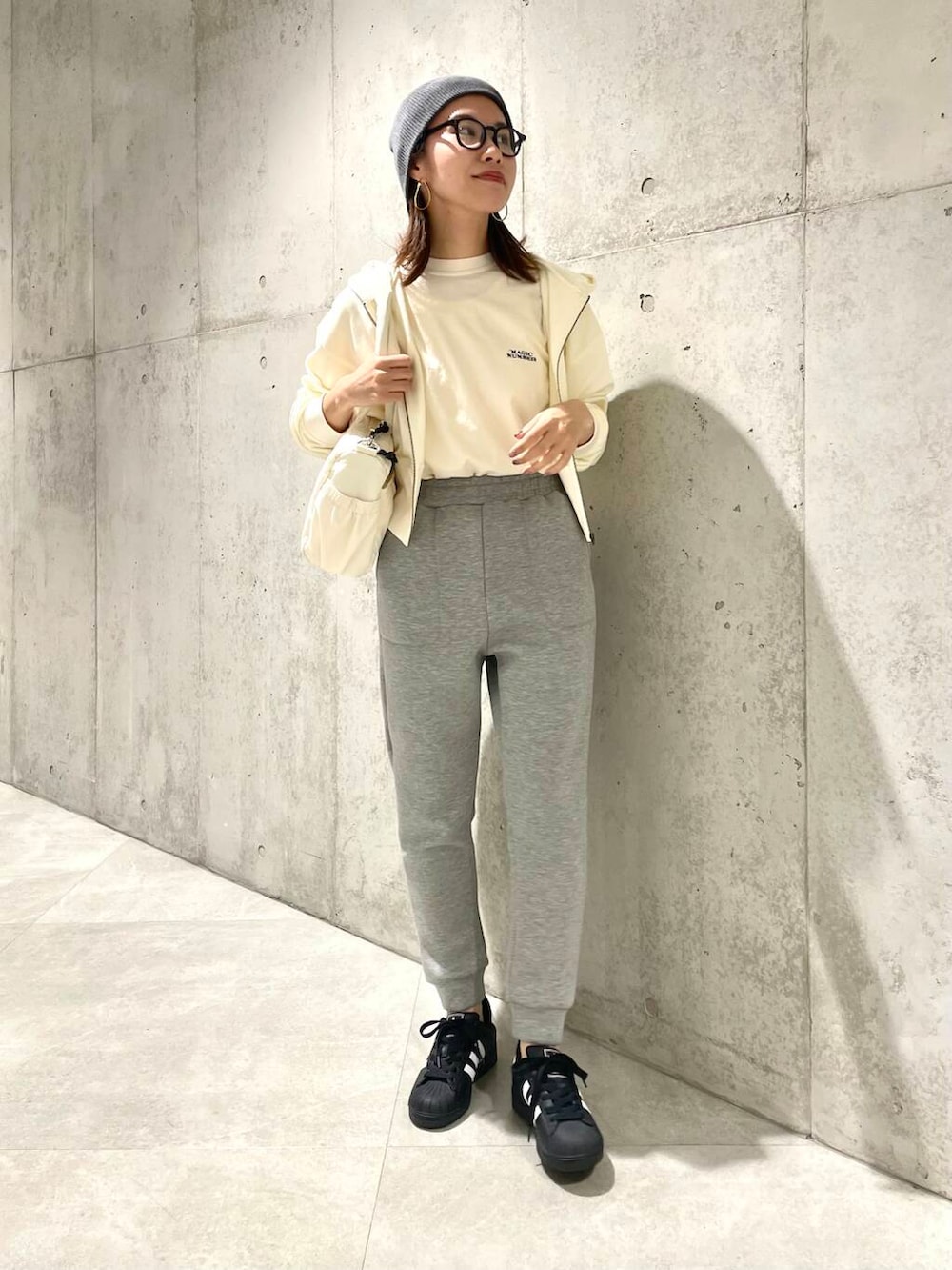 ブラック系のスニーカー、ホワイト系のTシャツ/カットソー、グレー系のその他パンツを着用したレディースの春コーディネートの2枚目の写真